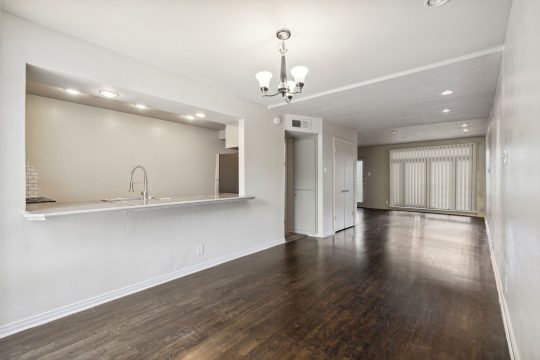 an empty room with hardwood floors and white walls at The  Le Parc